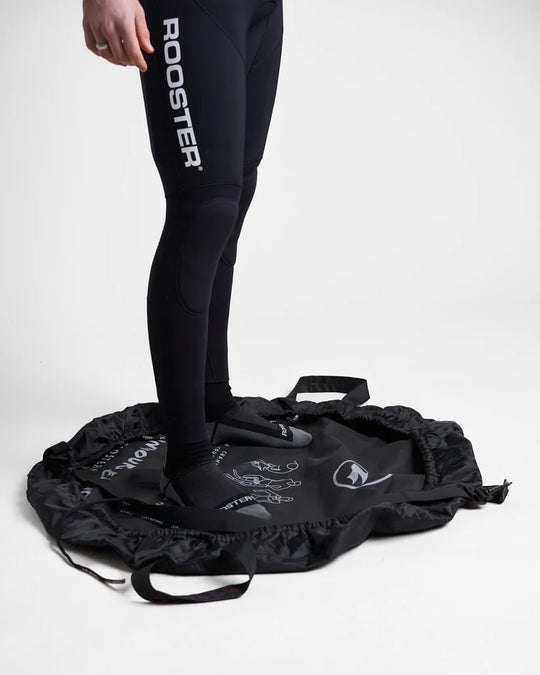 Close up of a studio image of the Rooster Changing Mat Bag showing a model stood in the open mat bag on a white background.