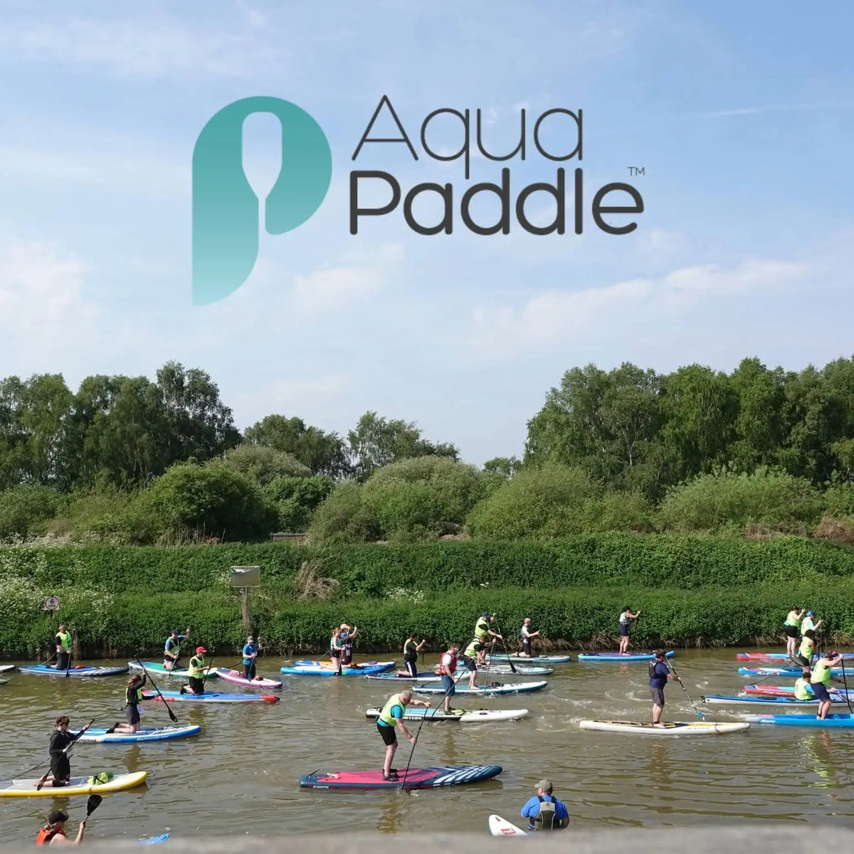Group of people paddleboarding on a river with 'AquaPaddle' logo above.
