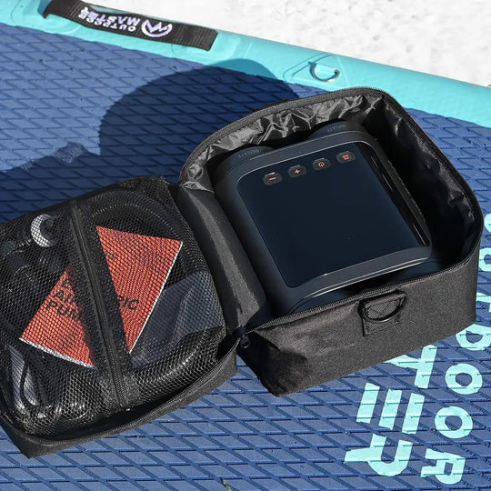 Black electronic SUP pump in a carrying case on a blue iSUP.