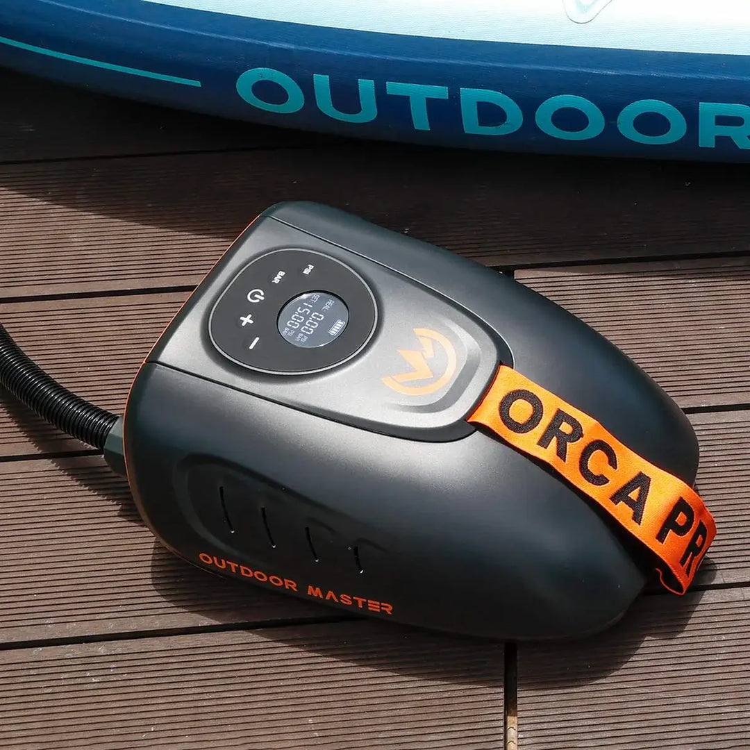 Black and orange Orca Pro electric SUP pump on a wooden surface with 'Outdoor Master' branding.