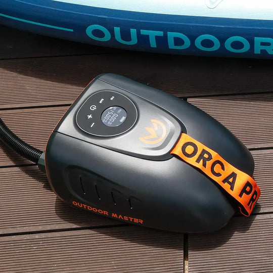 Black and orange Orca Pro electric SUP pump on a wooden surface with 'Outdoor Master' branding.