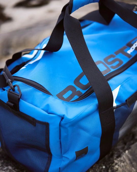 Blue duffel bag with black straps and 'ROOSTER' branding on a textured surface.