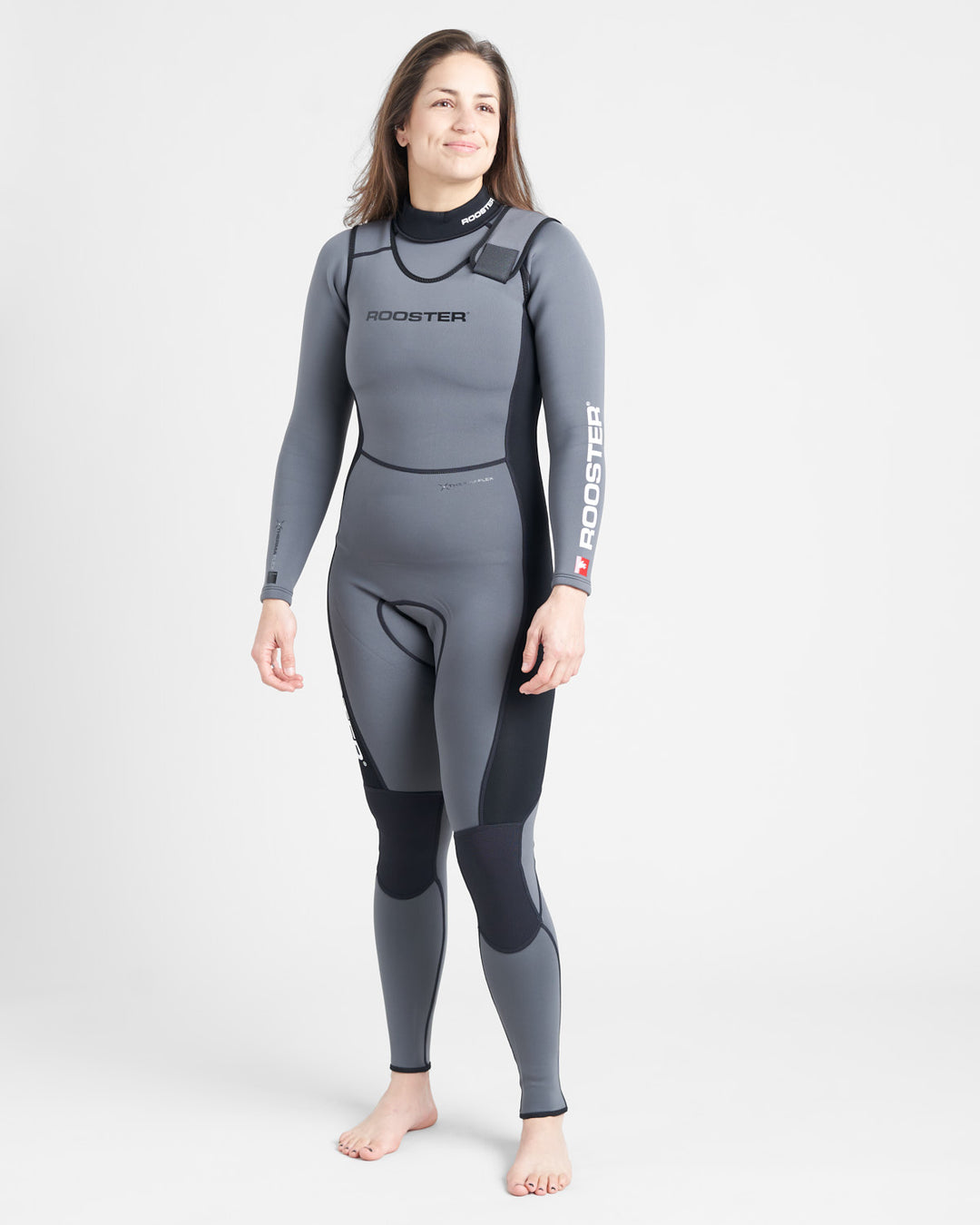 A person standing and smiling, wearing a gray long-sleeved wetsuit with black accents and the brand name 'ROOSTER' visible on the upper left thigh.