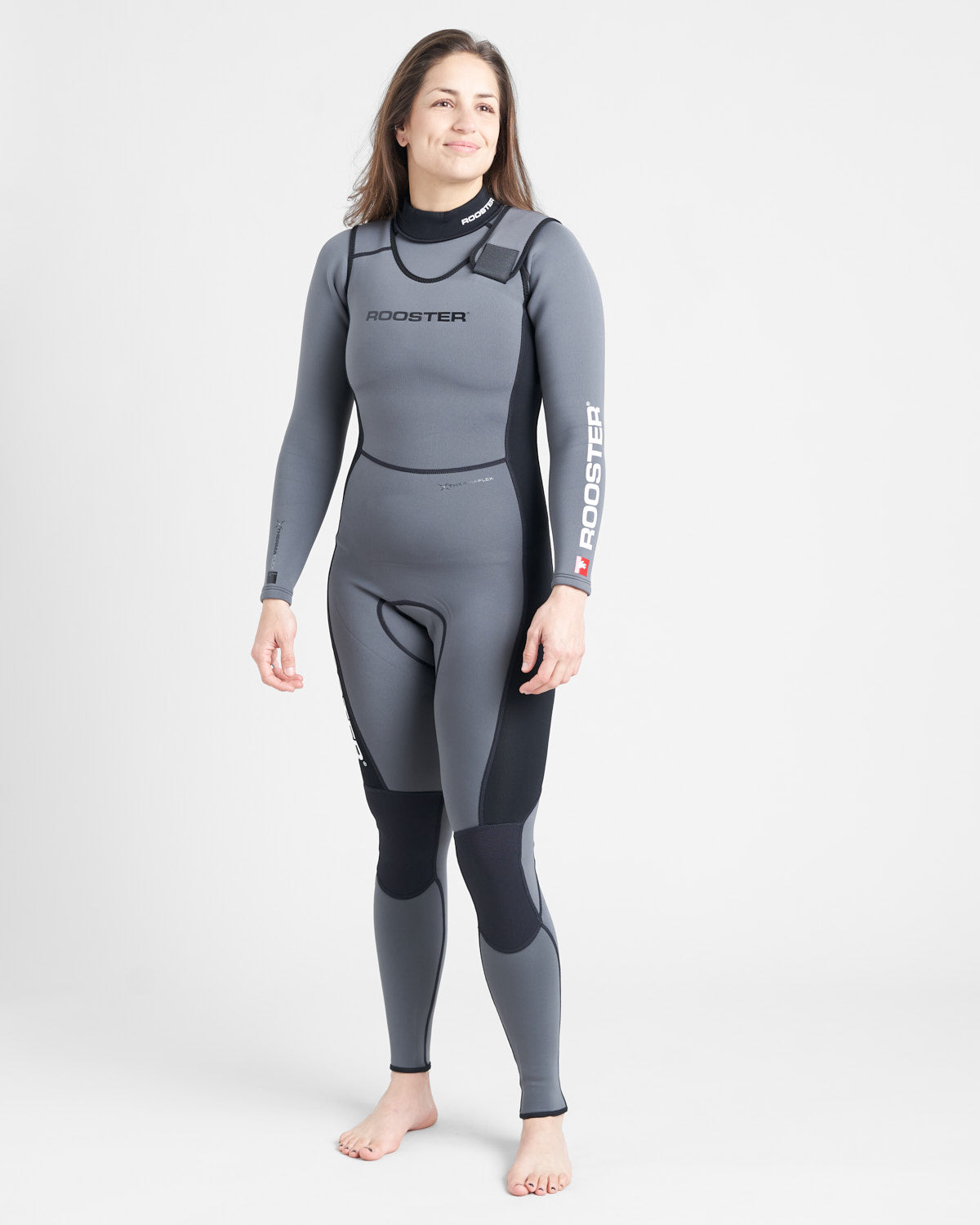 A person standing and smiling, wearing a gray long-sleeved wetsuit with black accents and the brand name 'ROOSTER' visible on the upper left thigh.