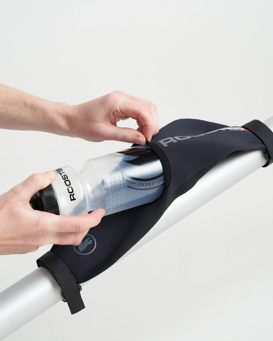 Person holding a bottle inside a black SUP and Sailing water bottle holder against a white background.