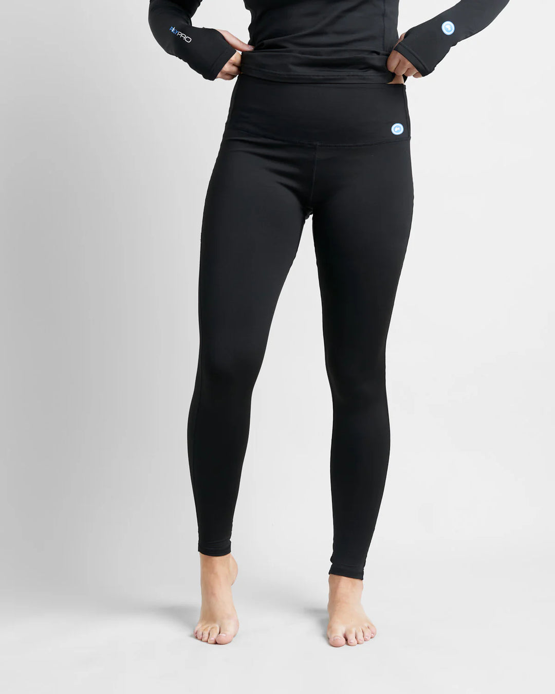 Person wearing black hydrophobic base layer leggings with a plain background.