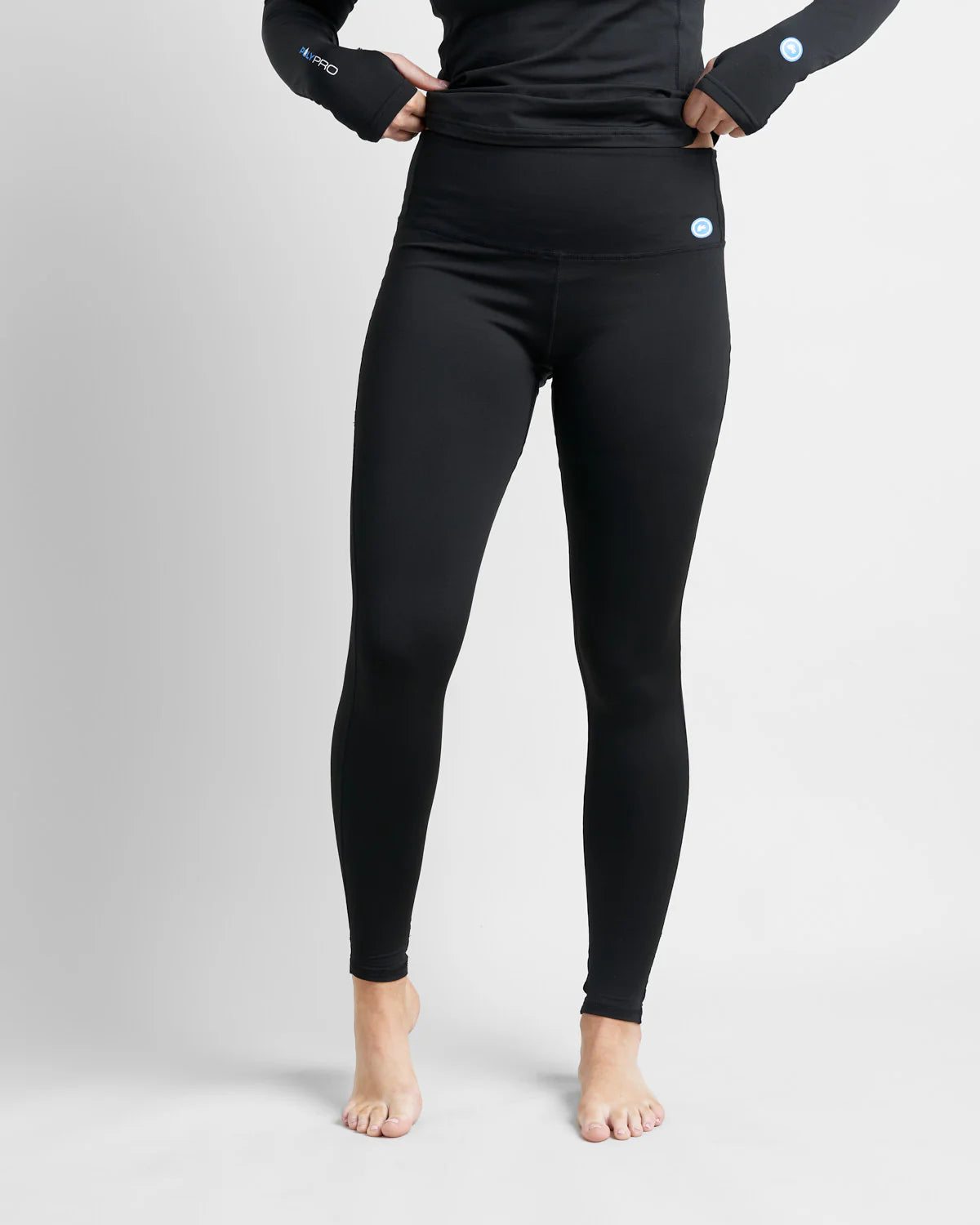 Person wearing black hydrophobic base layer leggings with a plain background.