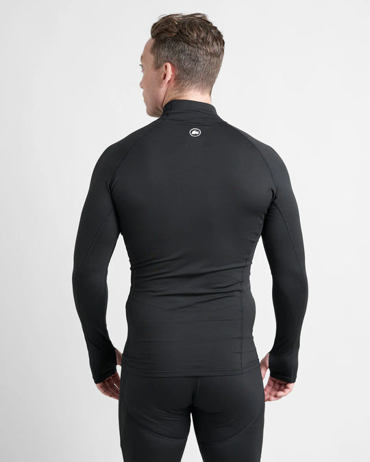 Person wearing a black long-sleeve base layer top with a logo on a light white background.