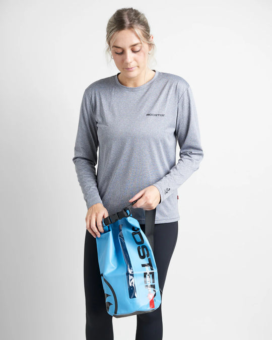 Person holding a blue dry bag with a white background.