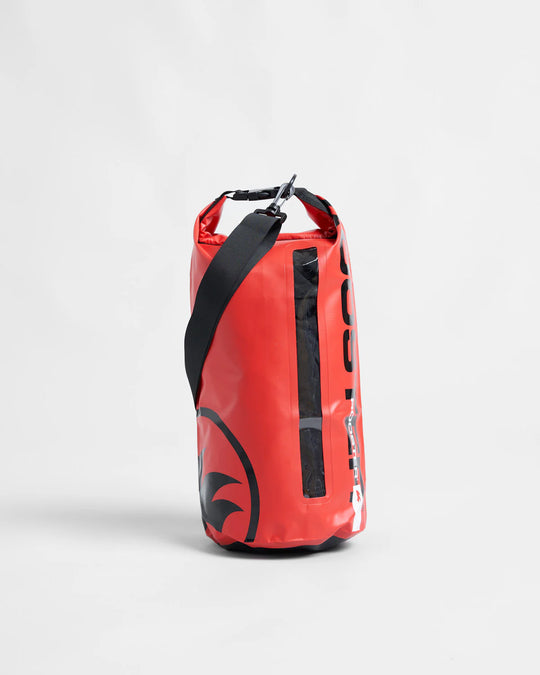 Red dry bag with black strap on a light grey background.