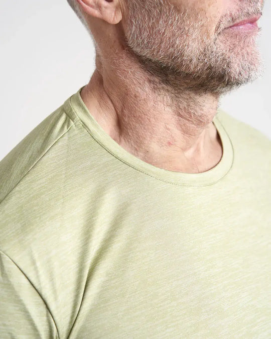 Close-up of a person wearing a light khaki t-shirt against a plain background.