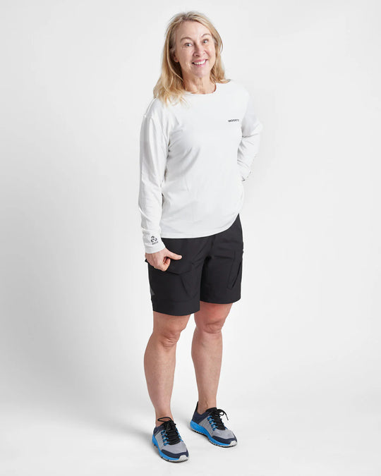Woman wearing a white long-sleeve quick dry t-shirt and black shorts on a white background.