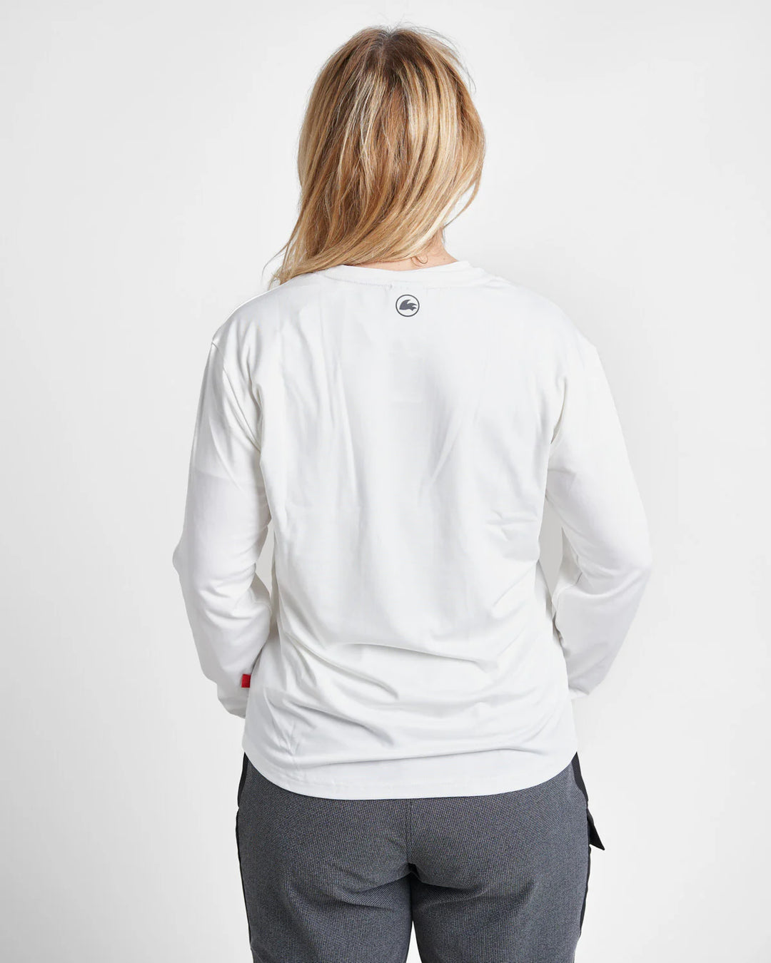 Person wearing a white quick dry t-shirt with a logo on the back against a light grey background.
