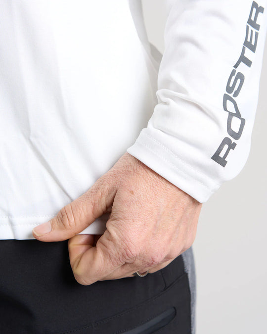 Person wearing a white long-sleeve quick dry t-shirt with 'Rooster' branding, adjusting their sleeve.