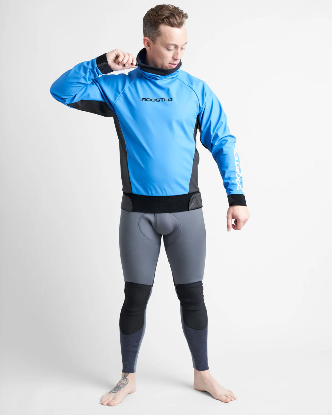 Person wearing a blue sailing top over a grey wetsuit with 'Rooster' branding on a white background.