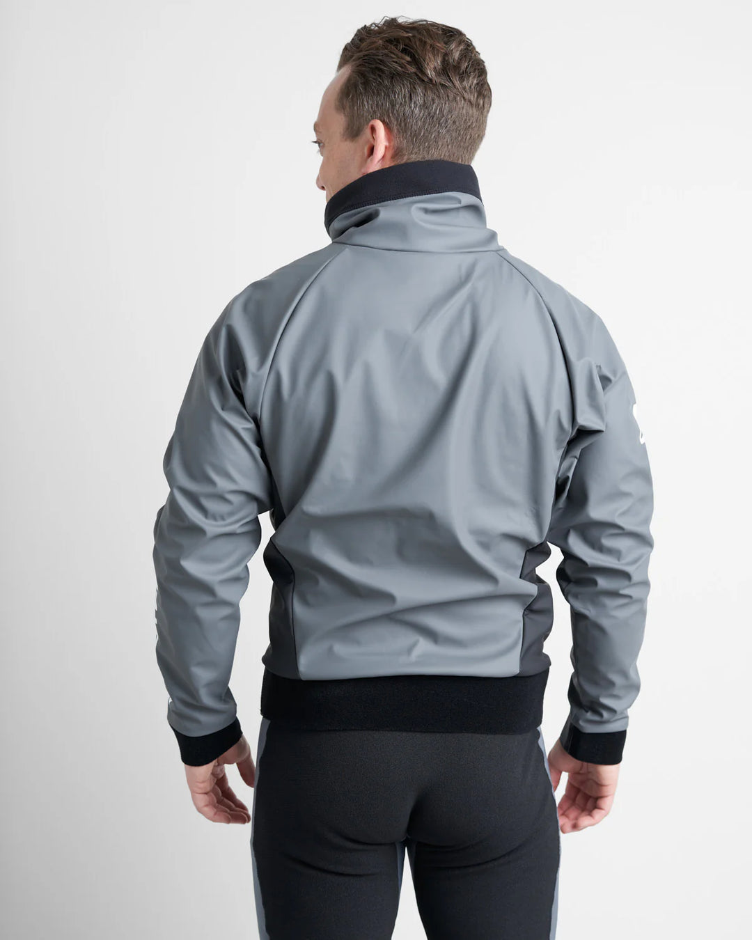 Man wearing a grey Aquafleece sailing spray top over a black wetsuit on a white background.