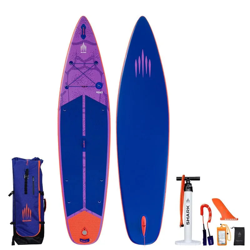 Image of Shark SUPS Roam 11'6 x 32" x 5" inflatable travel paddle board with light purple deck featuring shark skin graphics and a dark blue bottom. Also showing package accessories.