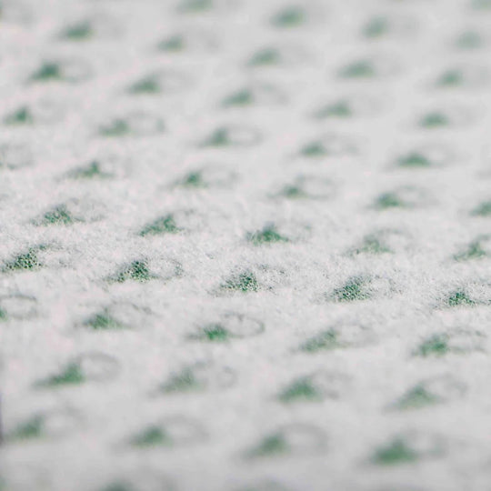 Close-up of a fleecy textured fabric with a subtle pattern on a white background.