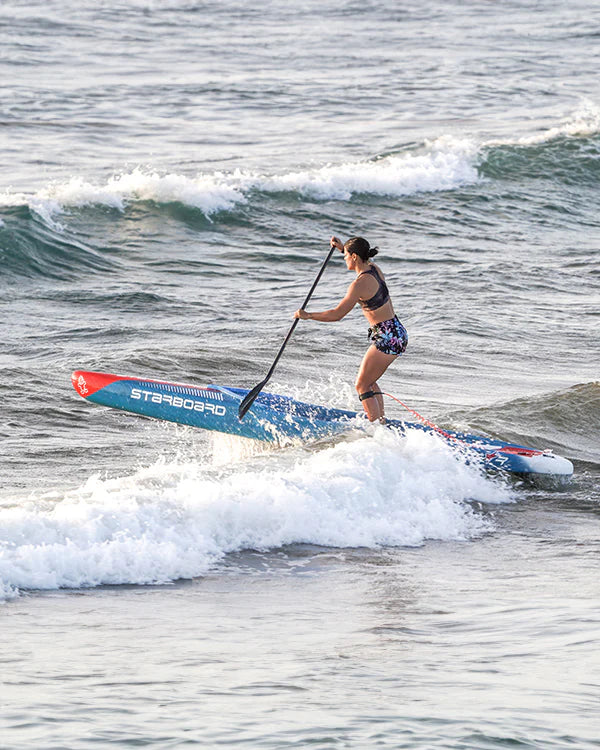 Woman paddleboarding on a Starboard board in the ocean.