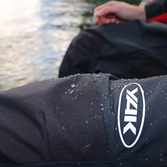 Model wearing Yak Chinook Dry trousers with a close up of the leg and water repellency.